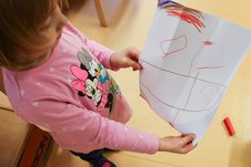 Ein Kind zeigt sein gemaltes Bild