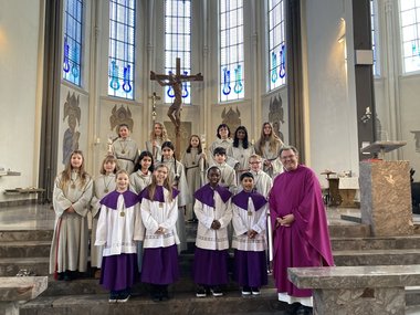 Die neuen Messdienerinnen stehen mit ihren Ausbildern und Pfarrer Wachtel vor dem Altarraum