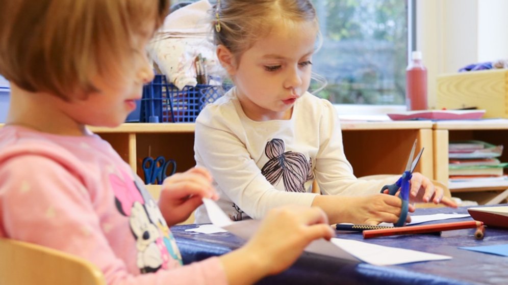 Zwei Kinder spielen am Tisch